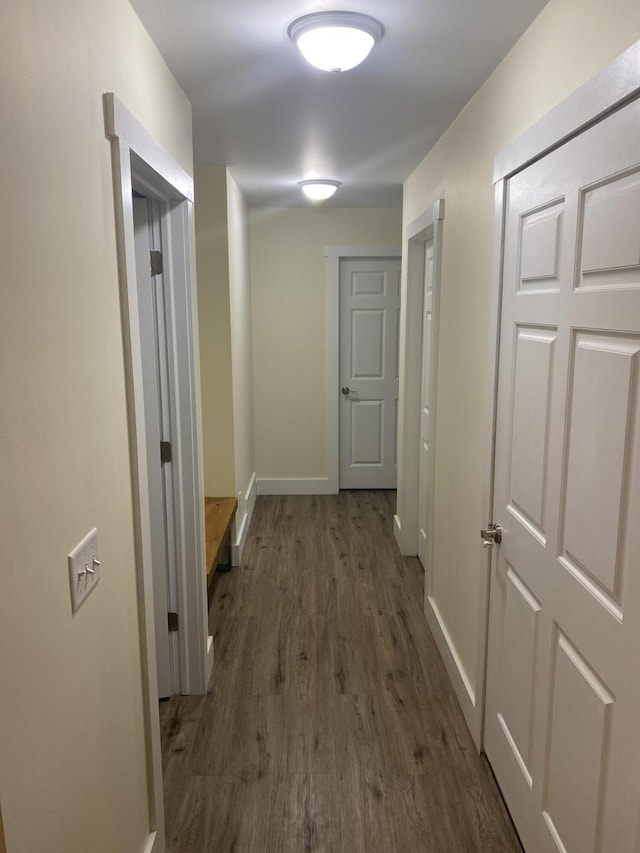 corridor with dark hardwood / wood-style flooring