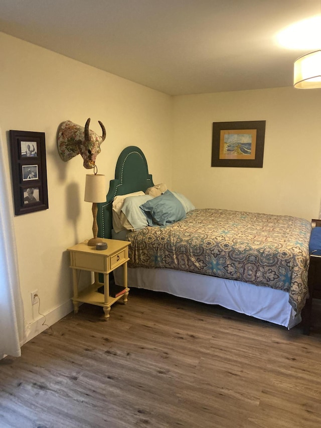 bedroom with dark wood-type flooring