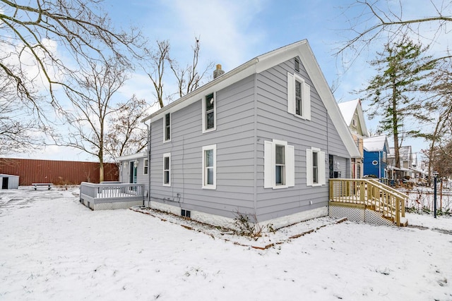 snow covered rear of property featuring a deck