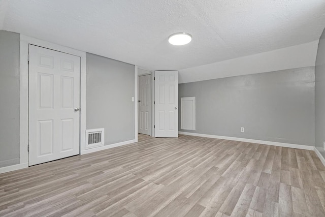 interior space featuring a textured ceiling and light hardwood / wood-style flooring