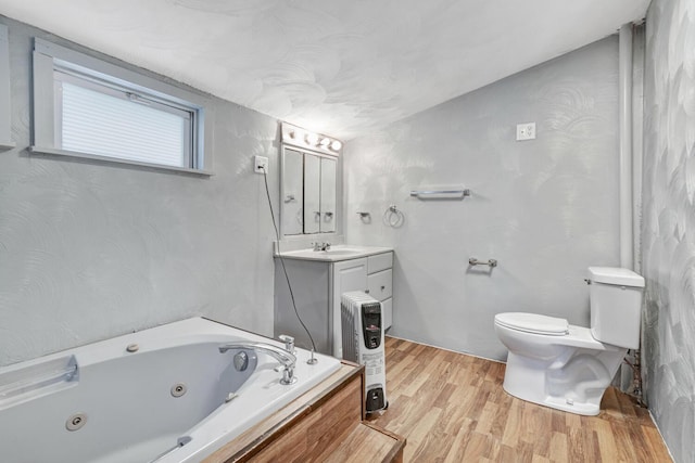 bathroom featuring vanity, wood-type flooring, a relaxing tiled tub, and toilet