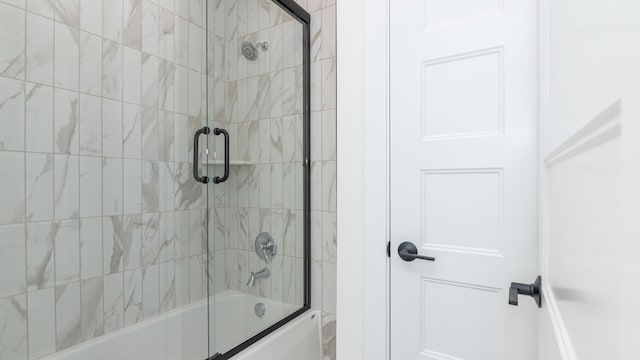 bathroom featuring bath / shower combo with glass door