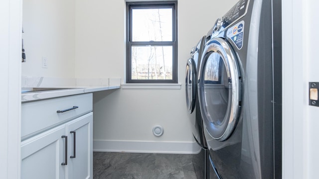 laundry room with washing machine and dryer, a wealth of natural light, and cabinets