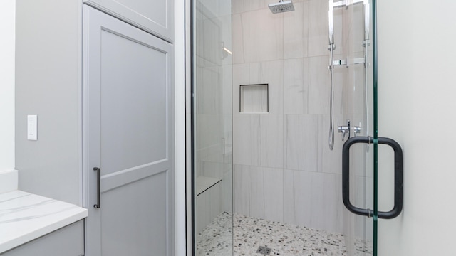 bathroom with vanity and a shower with door