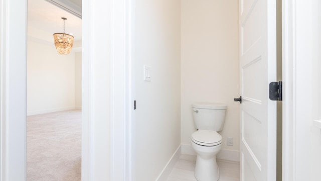 bathroom featuring a notable chandelier and toilet