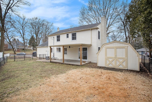 rear view of house with central AC, a lawn, and a patio