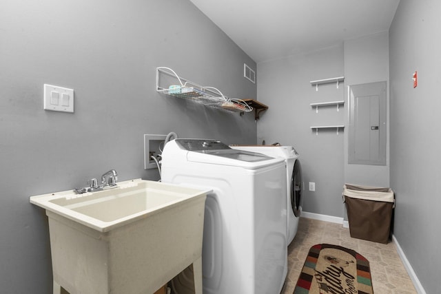 washroom featuring electric panel, sink, light tile patterned floors, and independent washer and dryer