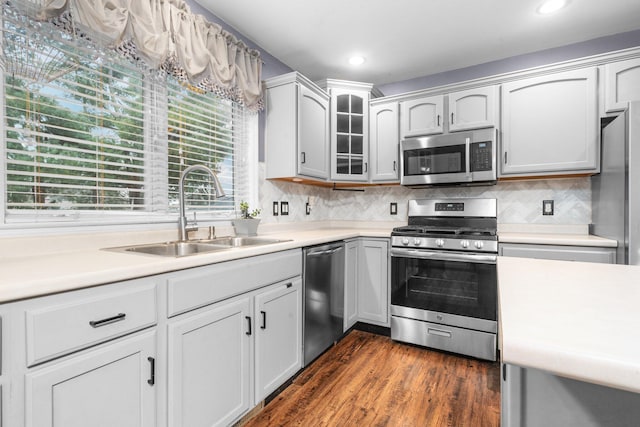 kitchen with backsplash, sink, dark hardwood / wood-style floors, and appliances with stainless steel finishes