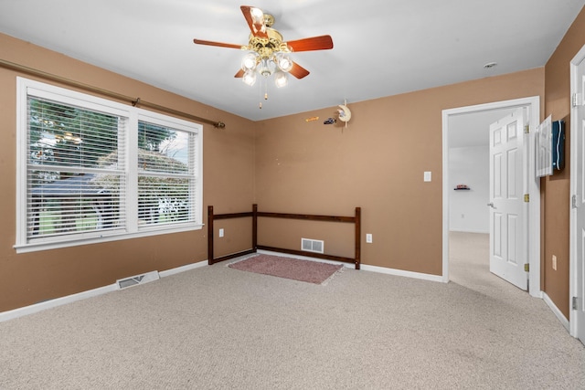 unfurnished room with ceiling fan and light carpet