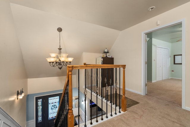 stairs featuring carpet flooring, lofted ceiling, and a notable chandelier