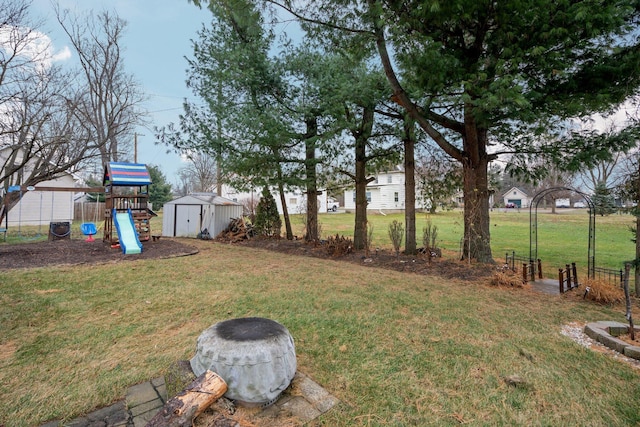 view of yard featuring ac unit, a playground, and a storage unit