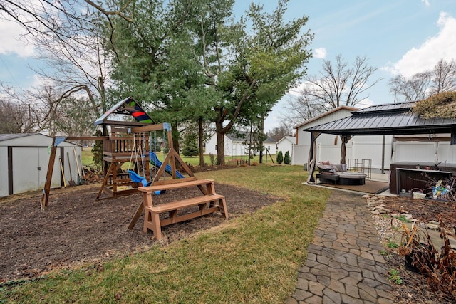 view of jungle gym with a gazebo, a lawn, and a hot tub