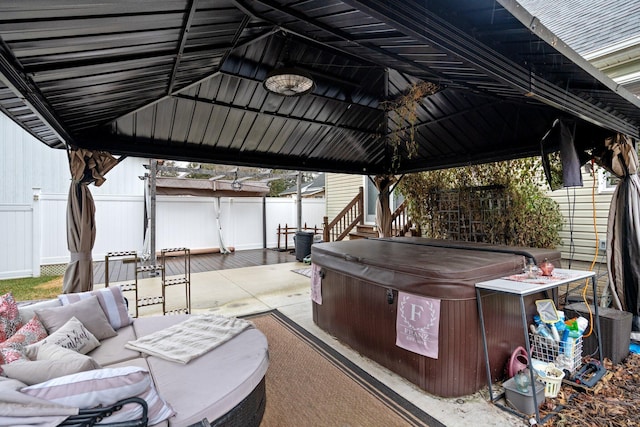 view of patio / terrace featuring a gazebo, an outdoor living space, and a hot tub