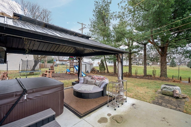 view of patio featuring a playground, a trampoline, and a hot tub