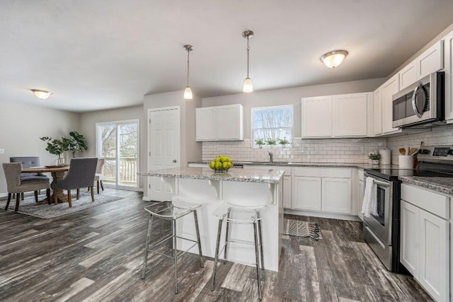 kitchen with plenty of natural light, white cabinets, and appliances with stainless steel finishes