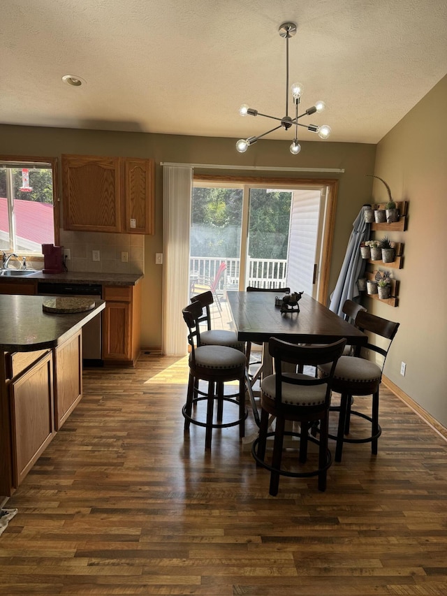 dining area with a notable chandelier, sink, and dark hardwood / wood-style flooring