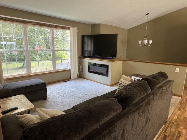 carpeted living room with vaulted ceiling and an inviting chandelier