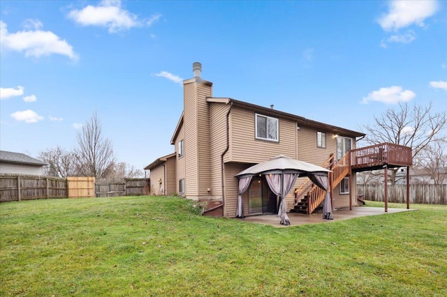 rear view of property with a gazebo, a wooden deck, a yard, and a patio