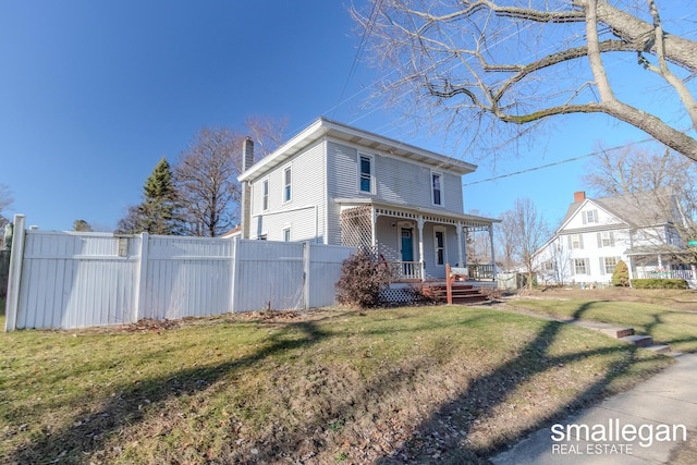 view of front of home with covered porch and a front lawn