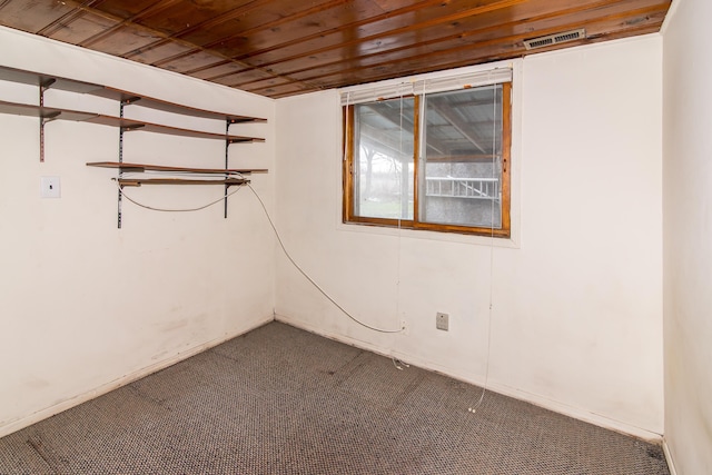 spare room featuring carpet flooring and wooden ceiling