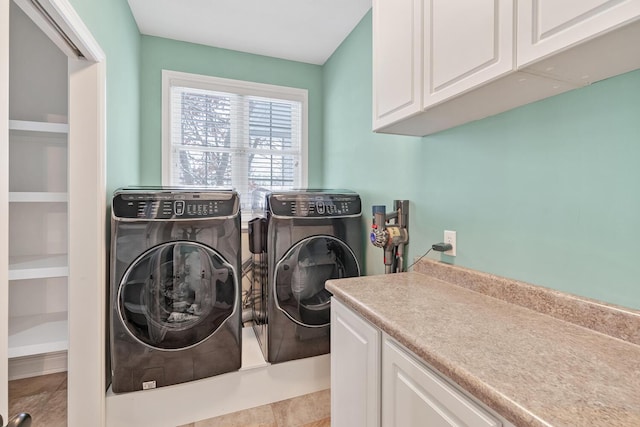 laundry room with cabinets, light tile patterned floors, and washing machine and dryer