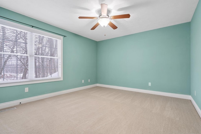 carpeted spare room featuring ceiling fan