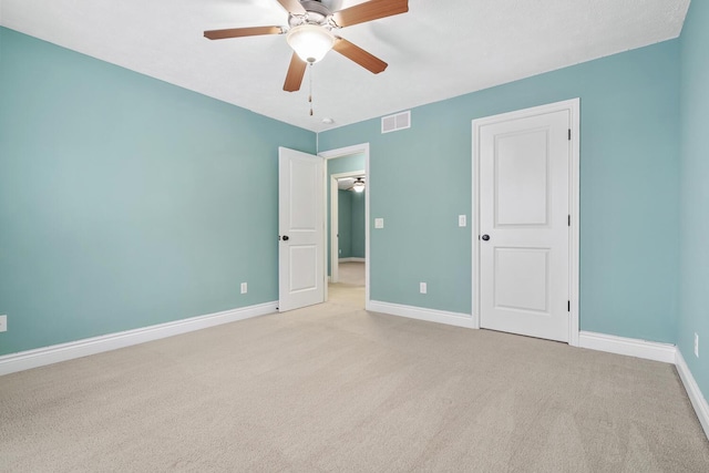 carpeted spare room featuring ceiling fan