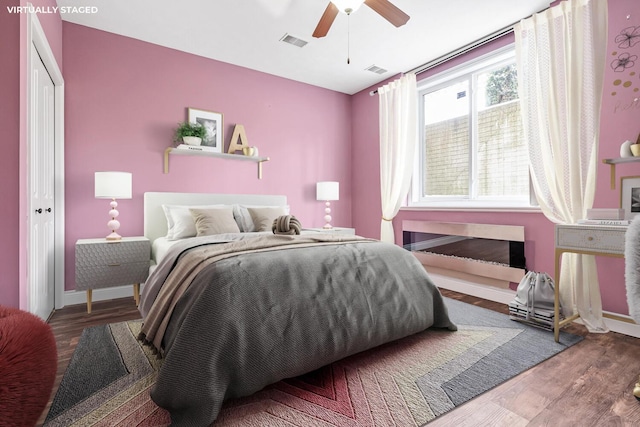 bedroom featuring hardwood / wood-style floors, ceiling fan, and a closet