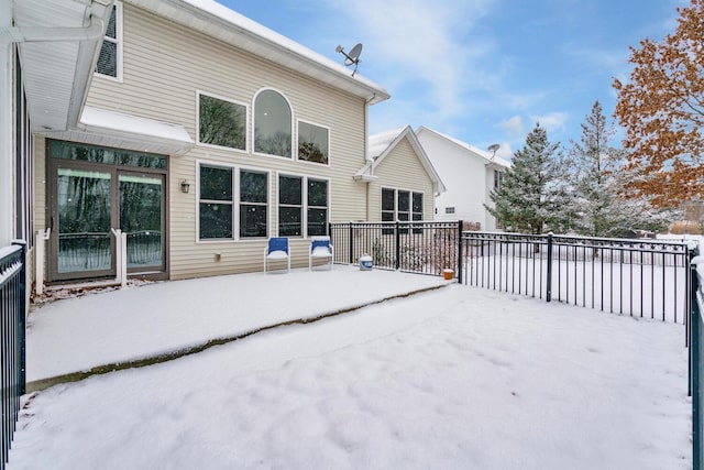 view of snow covered back of property