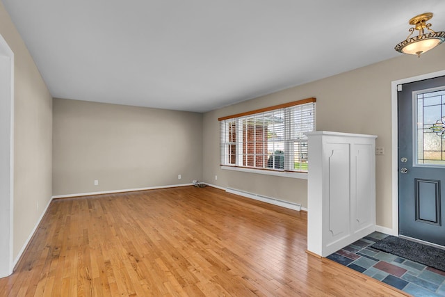 foyer entrance featuring hardwood / wood-style floors and a baseboard heating unit