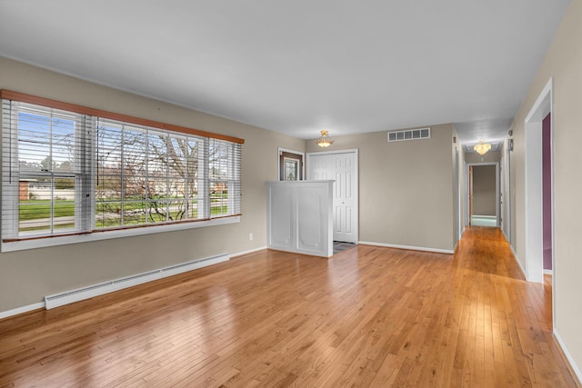 unfurnished room with light hardwood / wood-style flooring and baseboard heating