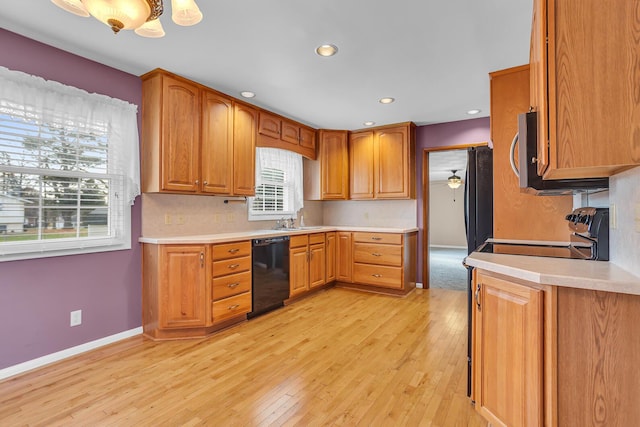 kitchen with backsplash, ceiling fan, sink, black appliances, and light hardwood / wood-style floors