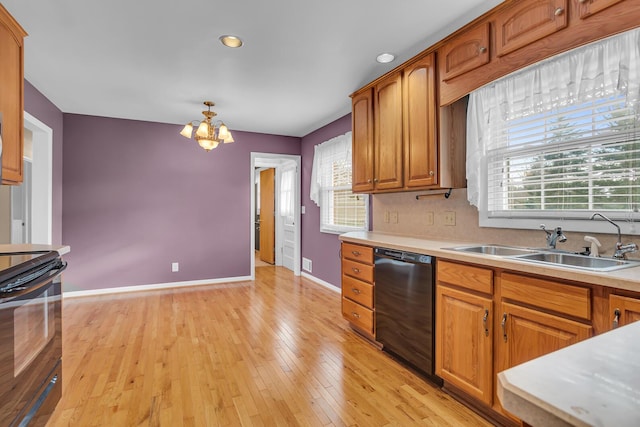 kitchen with decorative backsplash, light wood-type flooring, black appliances, a notable chandelier, and hanging light fixtures