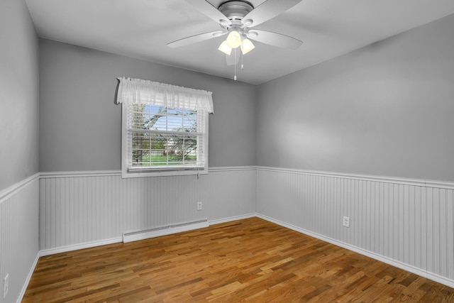 spare room with hardwood / wood-style floors, ceiling fan, and baseboard heating