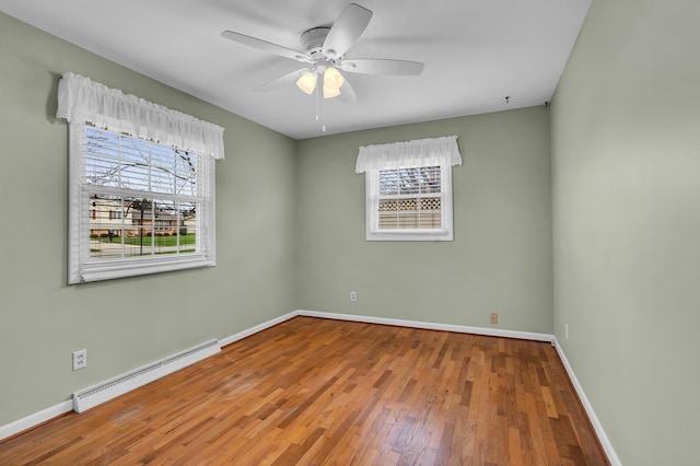 spare room with hardwood / wood-style floors, a baseboard radiator, and ceiling fan