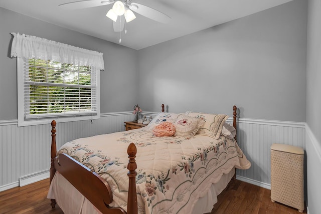 bedroom with ceiling fan, dark hardwood / wood-style flooring, and a baseboard radiator