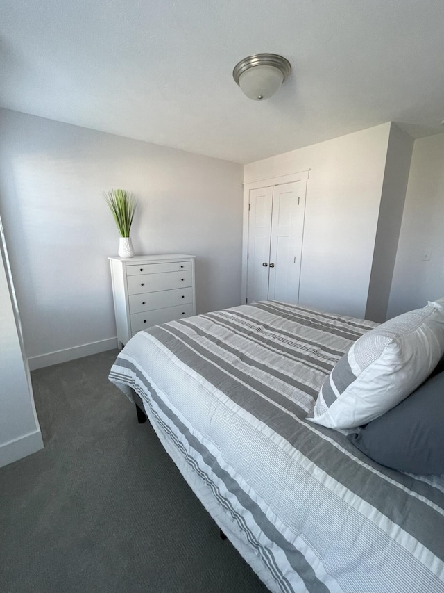 bedroom with dark carpet and a closet