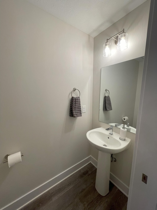 bathroom with hardwood / wood-style floors and a textured ceiling