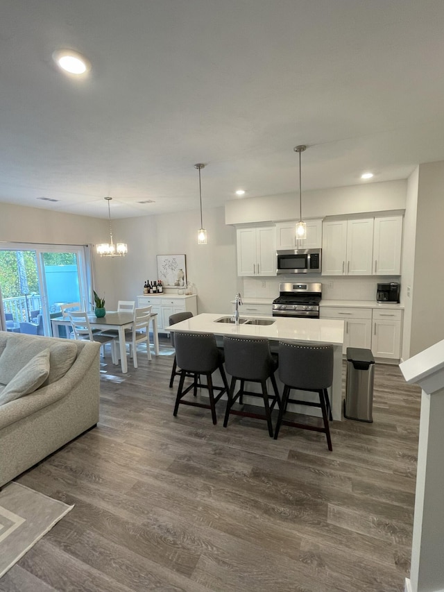 kitchen with white cabinets, dark hardwood / wood-style flooring, and stainless steel appliances