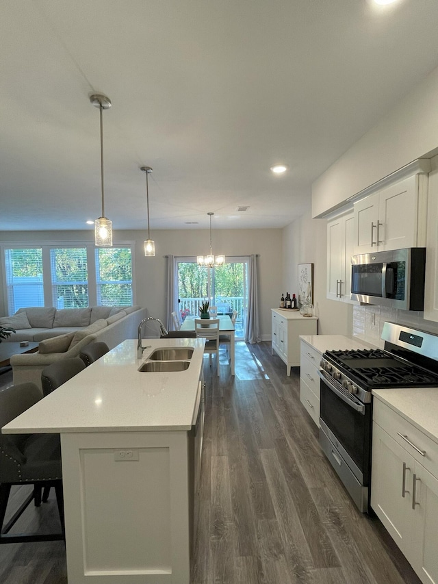 kitchen with sink, white cabinets, a center island with sink, and appliances with stainless steel finishes