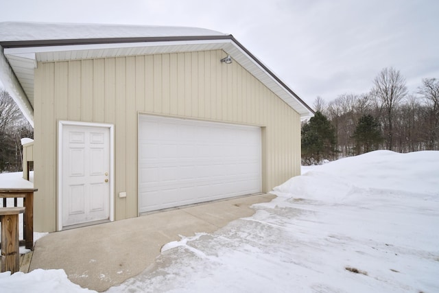 snow covered garage with a detached garage