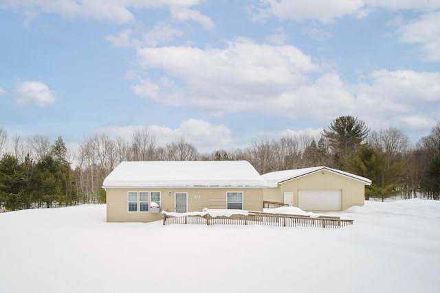 snow covered house featuring a garage