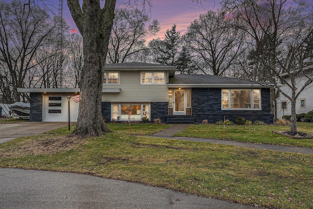 split level home featuring a lawn and a garage