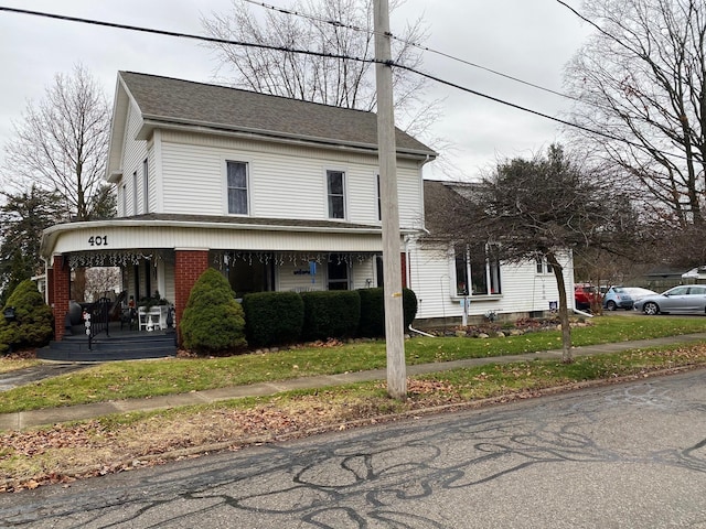 view of front property with covered porch and a front yard