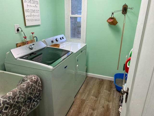 laundry area with wood-type flooring and washer and clothes dryer