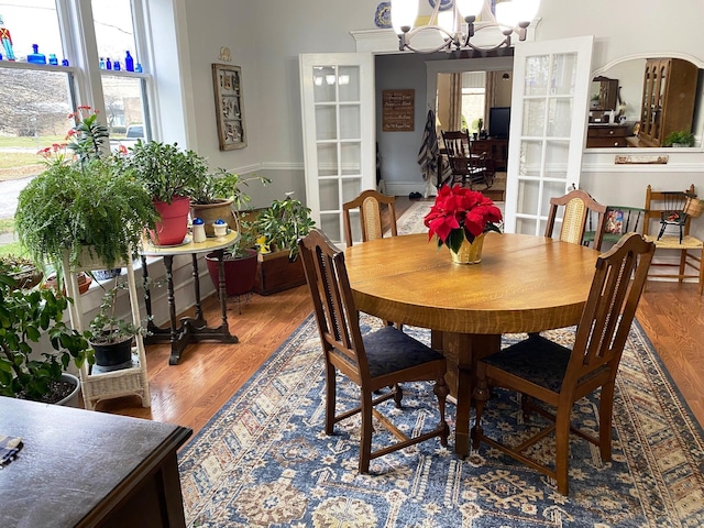 dining space with wood-type flooring and an inviting chandelier