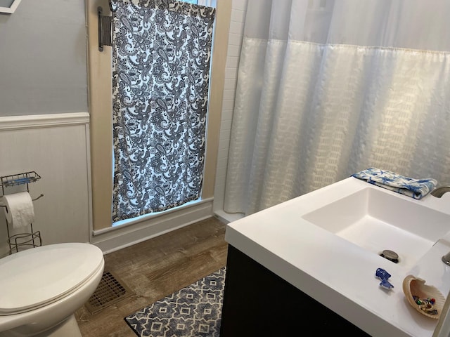 bathroom featuring a shower with shower curtain, toilet, wood-type flooring, and sink