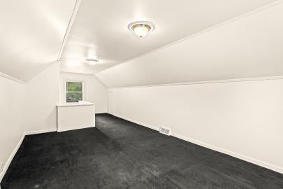 bonus room featuring dark colored carpet and lofted ceiling