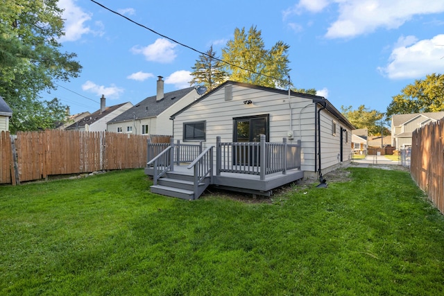 rear view of house featuring a yard and a wooden deck