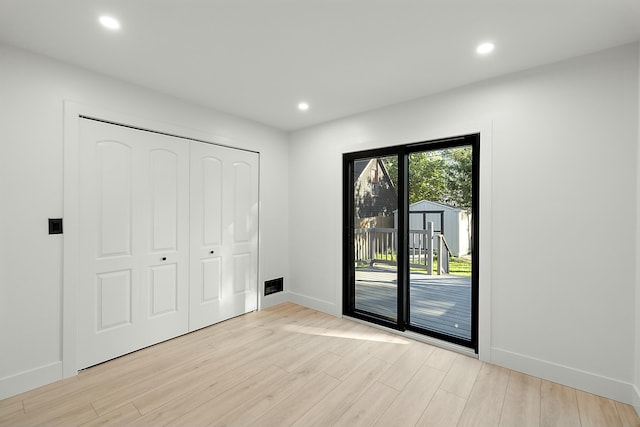 interior space with access to outside, a closet, and light hardwood / wood-style floors